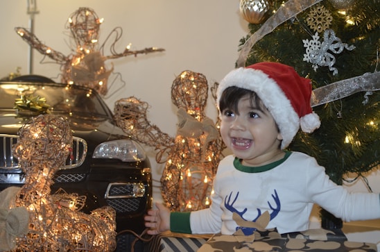 A joyful child writing a letter to Santa at a festive desk.