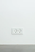 Modern electrical outlet installed on a clean white wall in an apartment.