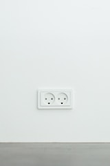 An electrician installing a new electrical outlet in a modern home.