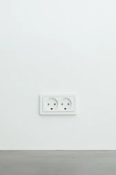 Modern white electrical outlet installed near a kitchen countertop.