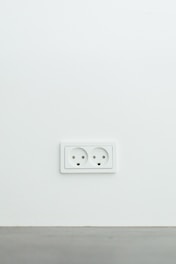 An electrician repairing an electrical outlet in a modern home environment.