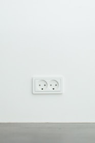 Close-up of a sleek modern electrical outlet with USB ports installed on a white wall.