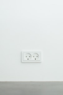 An electrician repairing an electrical outlet in a modern home environment.