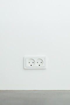 An electrician repairing a wall socket in a home.