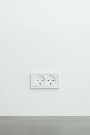 A handyman replacing electrical outlets in a cozy home office space.