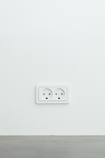 Close-up of a modern electrical outlet installed on a clean white wall.