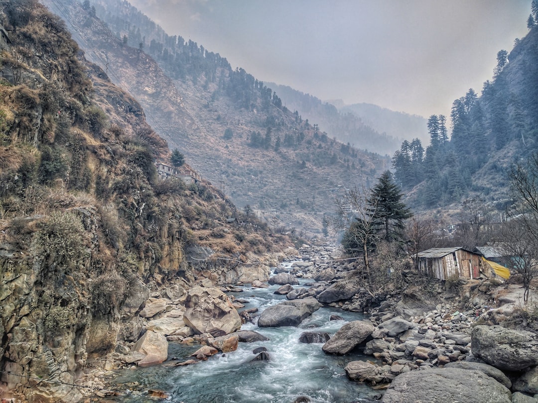 house near river surrounded with mountains, Creek among hills