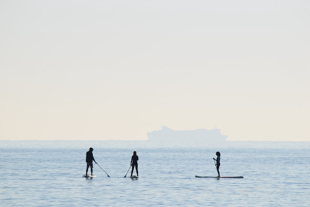 persone che cavalcano su tavole da paddle