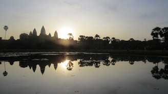 A serene image of an ancient Shiva temple at sunrise with a soft orange sky.