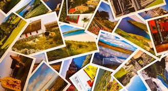A collection of postcards spread out on a wooden table, their edges worn and colors muted.