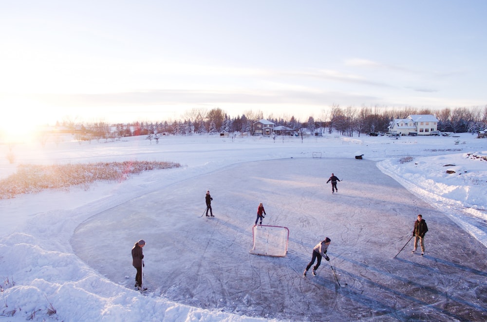 Grupo de personas que juegan al hockey al aire libre durante el invierno