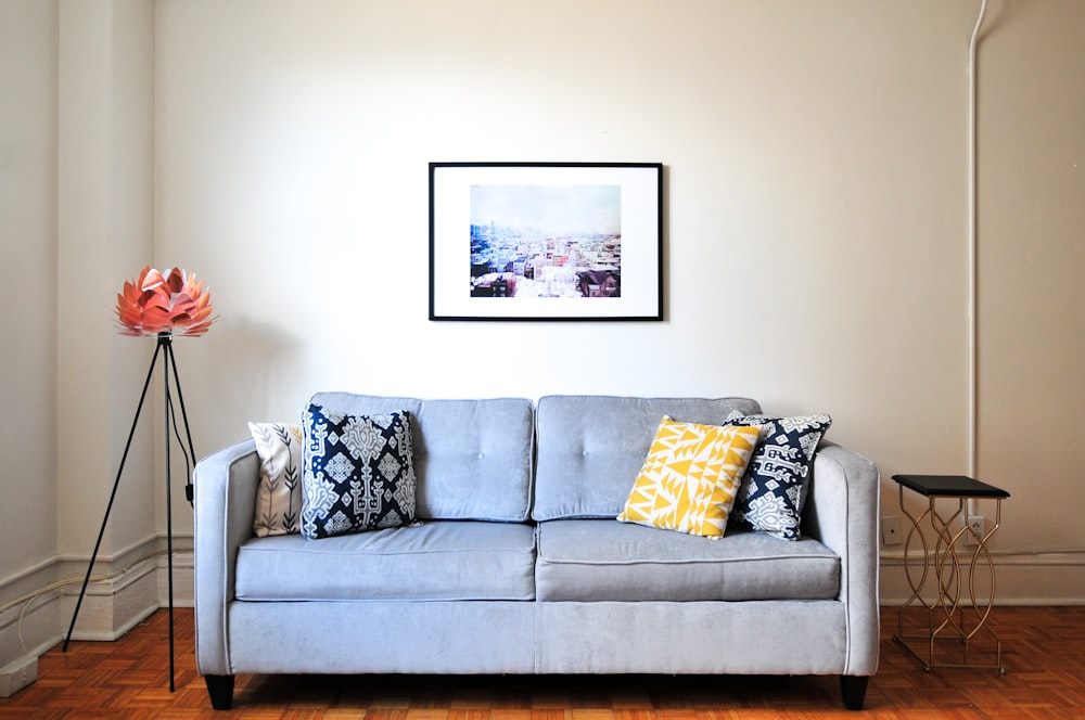 Gray couch with decorative pillows and unique art in a cozy apartment living room