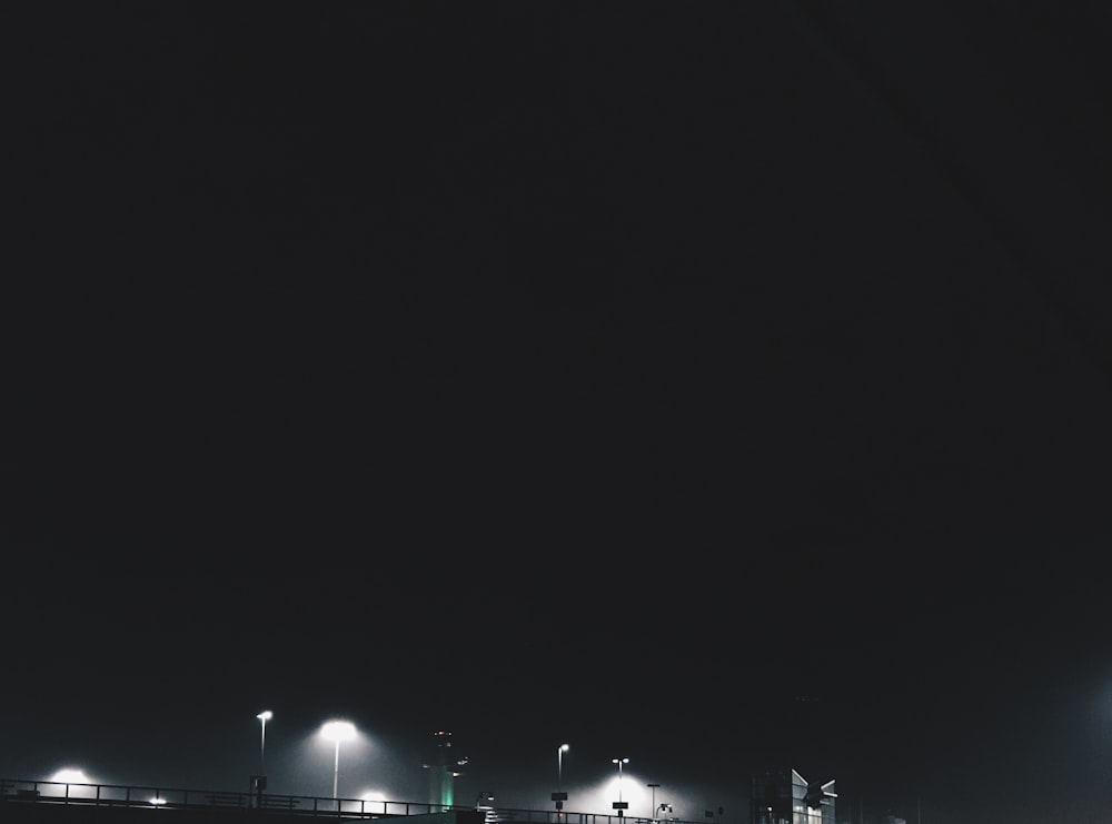 Una foto en blanco y negro de un puente por la noche