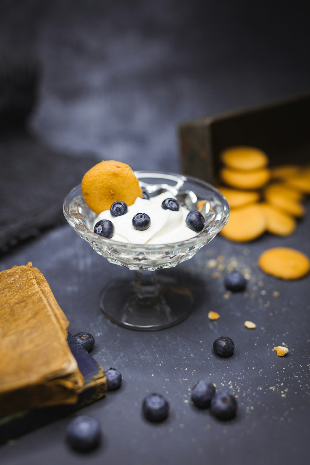 Fotografia de foco raso de iogurte em vidro com mirtilos no topo