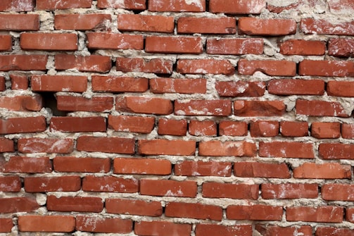 Detail of a brick wall being restored with fresh mortar.