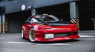 red coupe on gray concrete ground