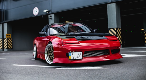 red coupe on gray concrete ground