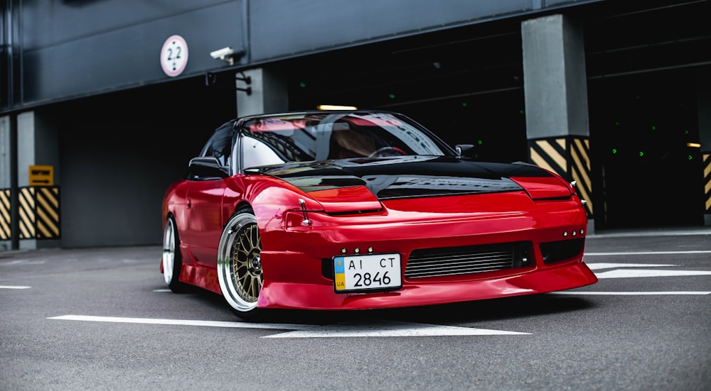 red coupe on gray concrete ground