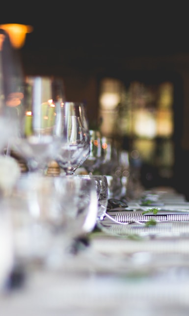 focused photo of wine glasses lined on table