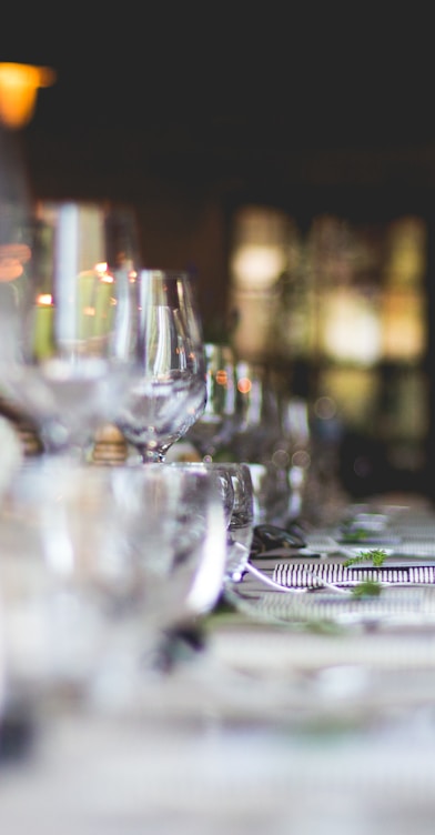 focused photo of wine glasses lined on table