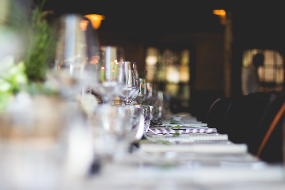 focused photo of wine glasses lined on table