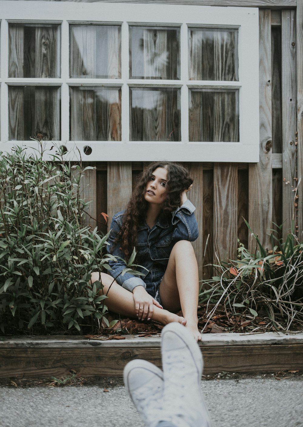 woman sitting under white wooden window