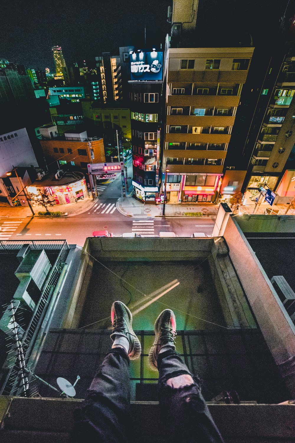 Mann sitzt auf dem Dach mit Blick auf die Stadt