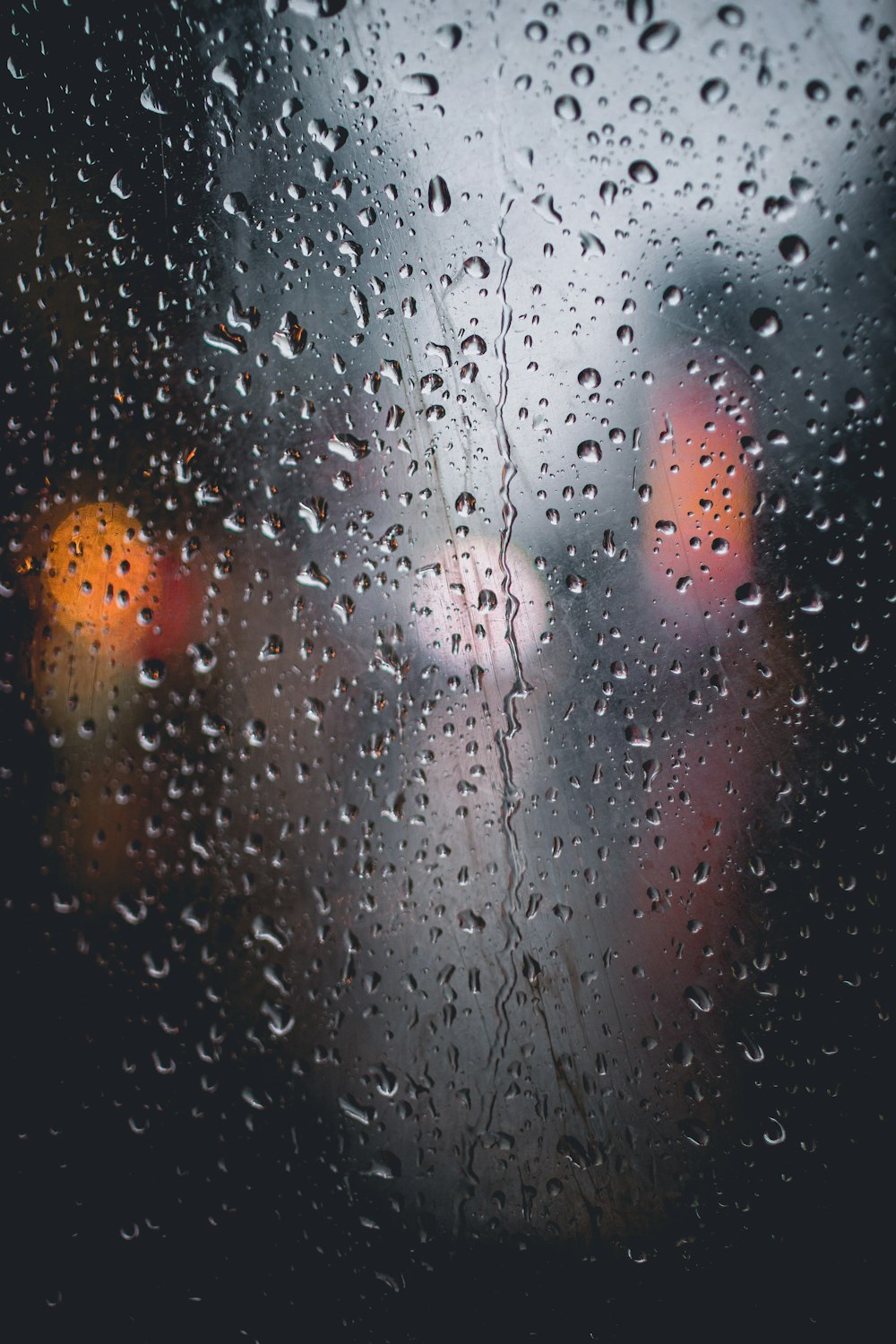 rain drops on a window with traffic lights in the background