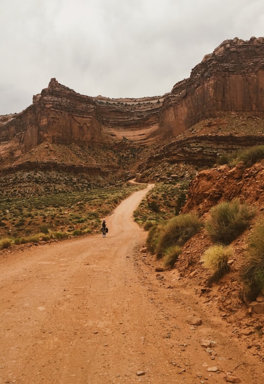 person walking on walkway near mountains in Canyonlands National Park United States