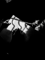 Close-up of a writer's hand sketching story ideas in a notebook with warm amber lighting