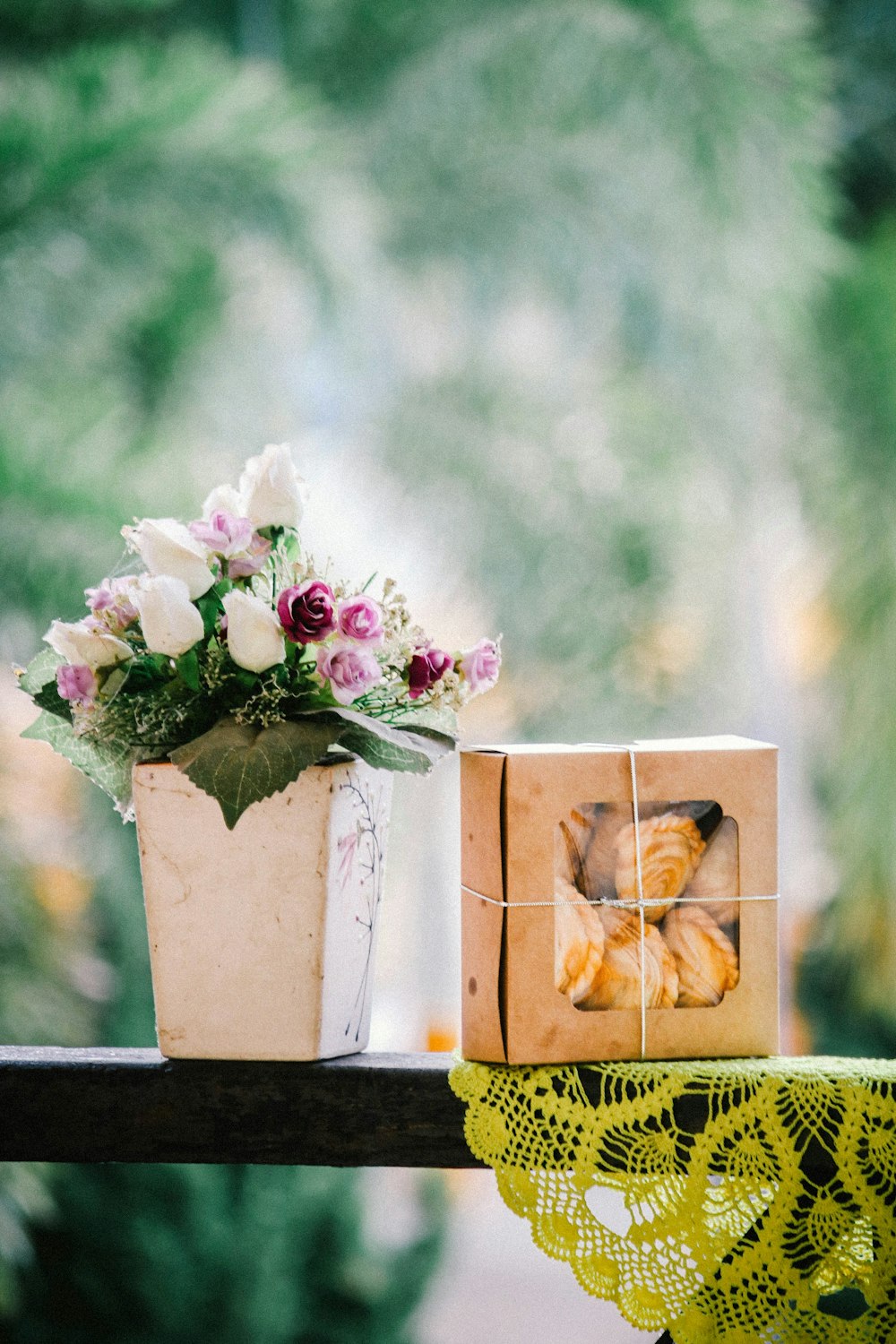 white rose bouquet in ceramic vase on wooden fence