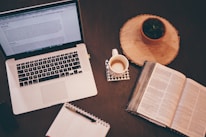 A snapshot of a cozy workspace with a laptop, notebook, and coffee cup.