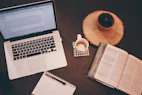 Modern office workspace with documents, laptop, and coffee cup on a white desk.