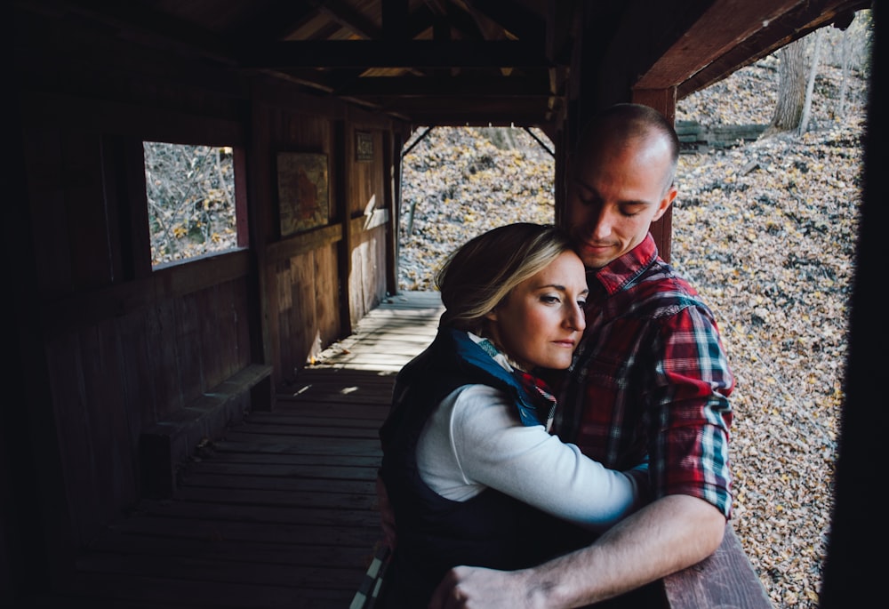 woman hugging man inside bridge during daytime