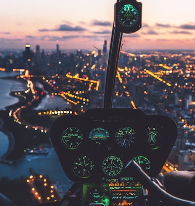 aerial view photography of helicopter cockpit and cityscape by water