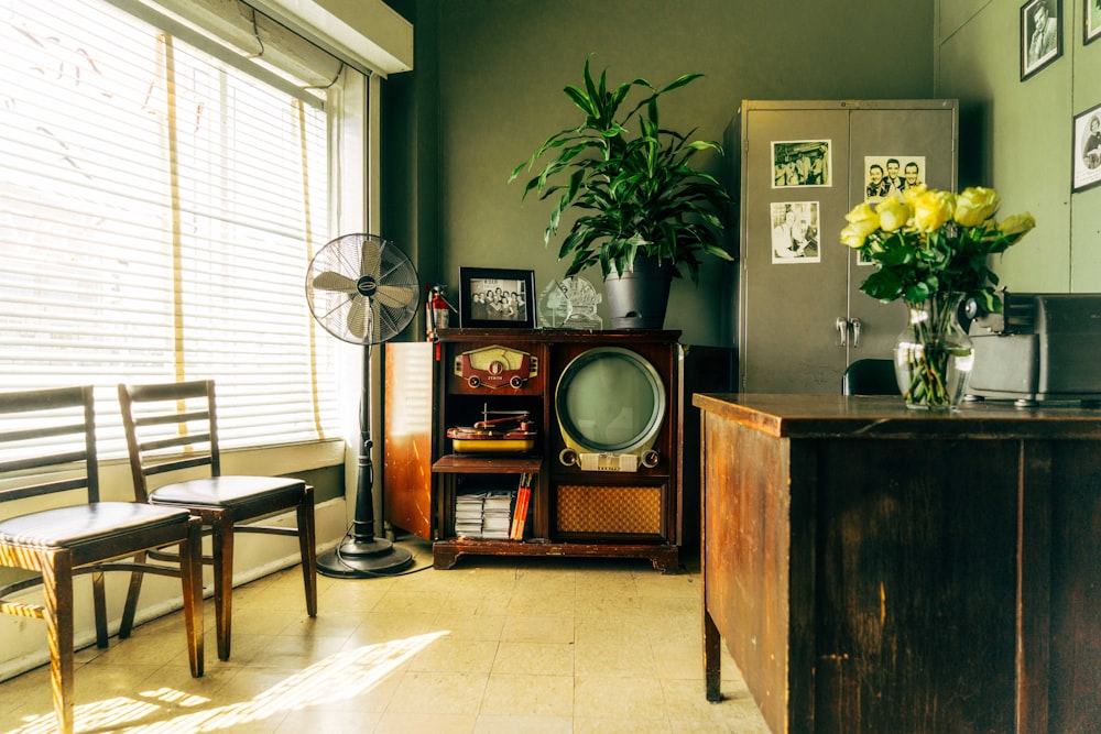 grey pedestal fan near brown wooden rack inside house