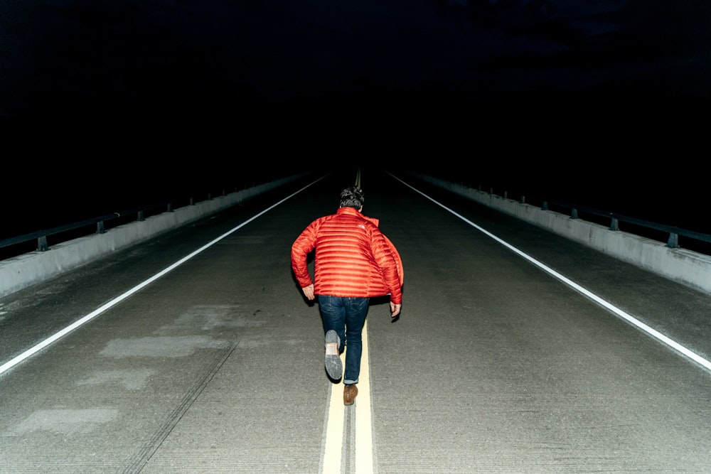 man running on road during night time
