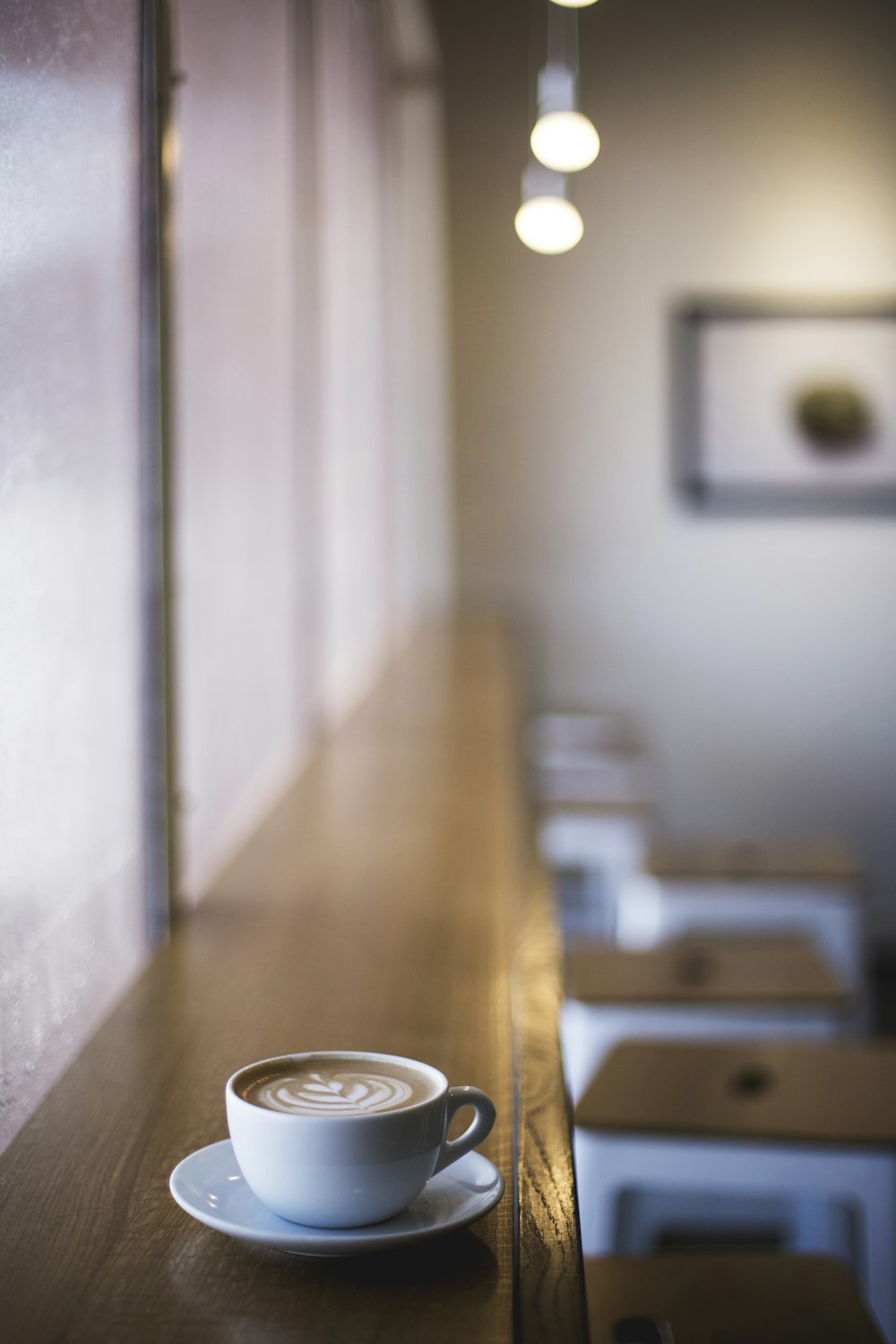 cup filled with coffee frother on saucer