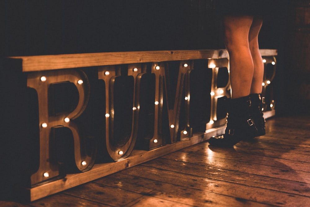 woman standing in front of brown rumble marquee sign on floor