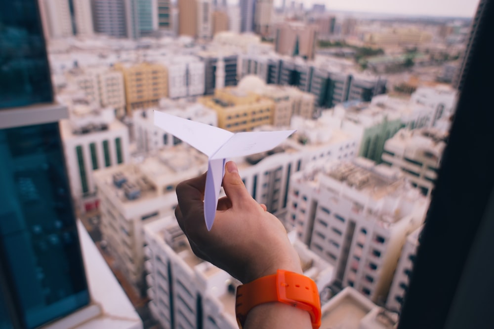 shallow focus photography of person holding paper plane