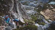 several mountain climbers on cliff of rock mountain at daytime