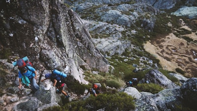 several mountain climbers on cliff of rock mountain at daytime