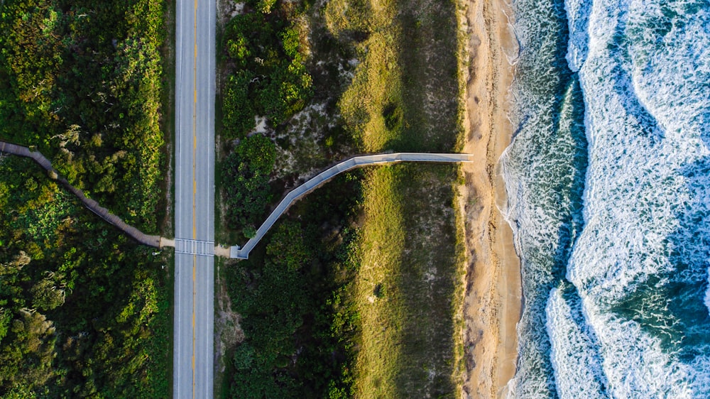 Foto aérea de estrada cinza perto do oceano durante o dia