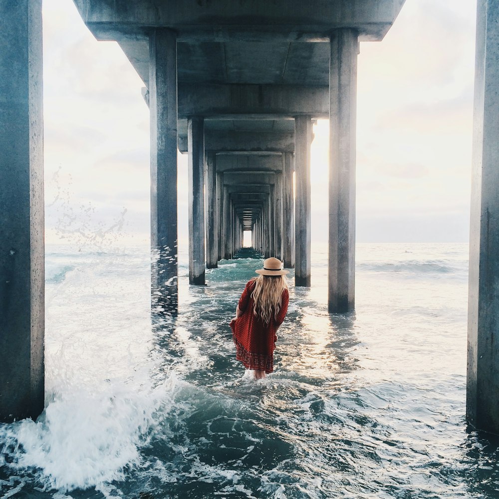 person in red dress in ocean during daytime