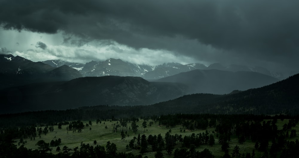 silhouette mountains under cloudy sky