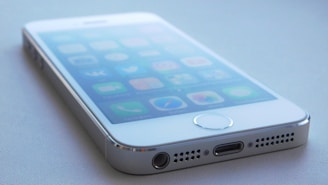 A close-up of a smartphone with a voice assistant interface on the screen.