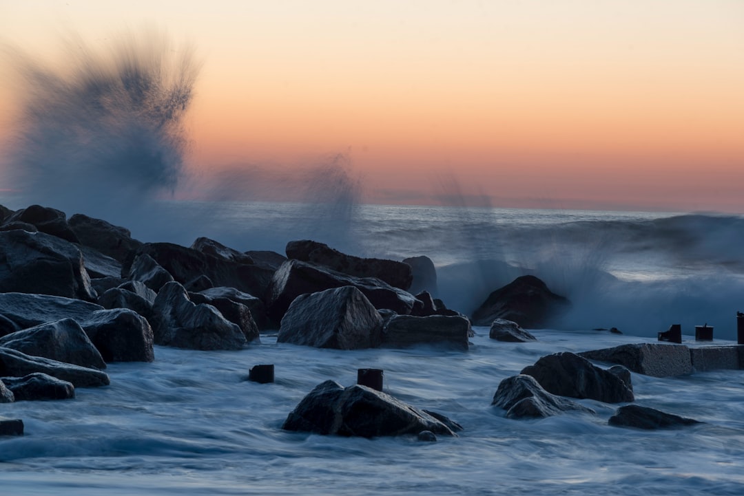 black rocks of splashing body of water