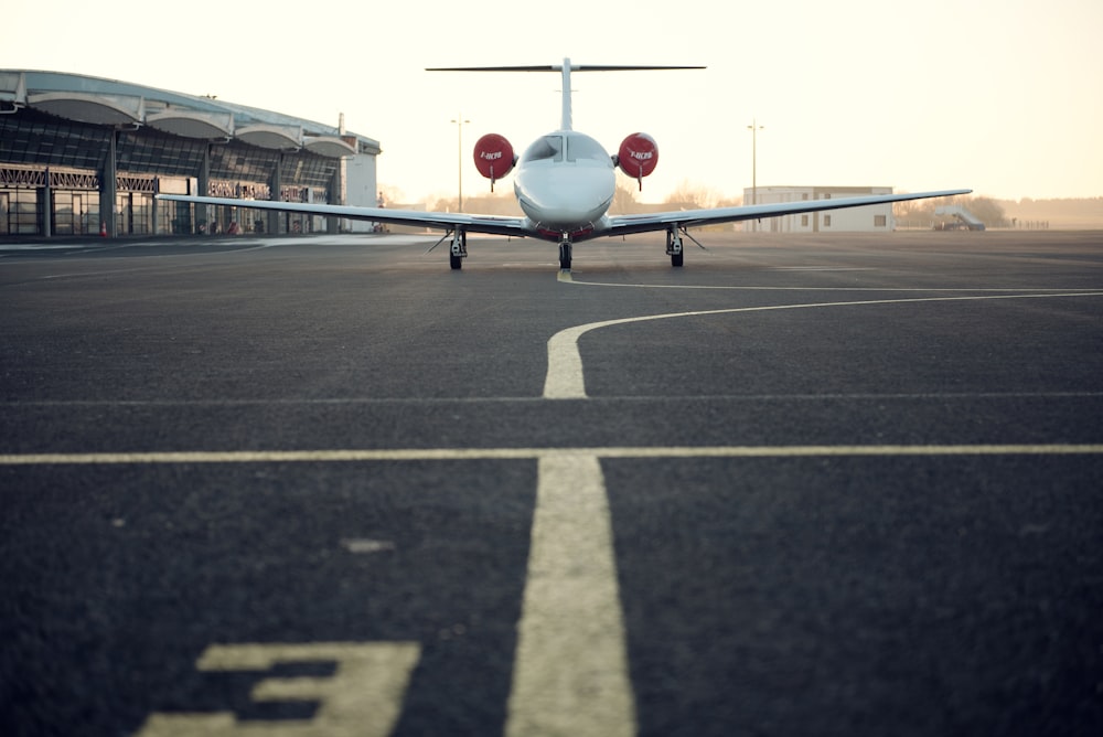 Avião privado branco na pista de pouso