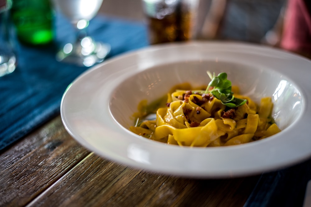 Pasta con salsa en bol de cerámica blanca