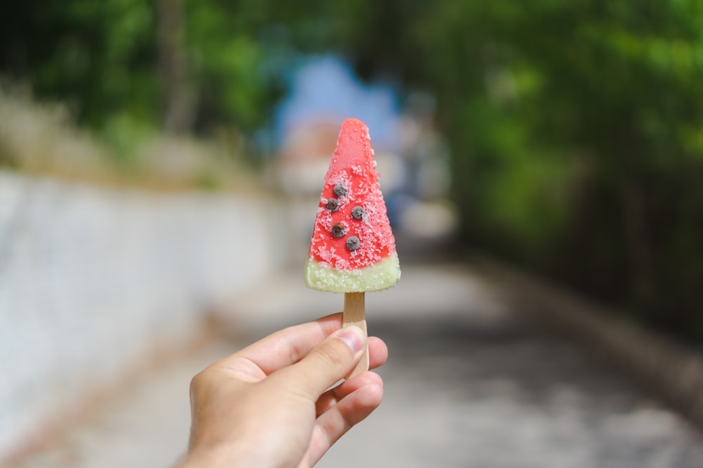 person holding popsicle during daytime